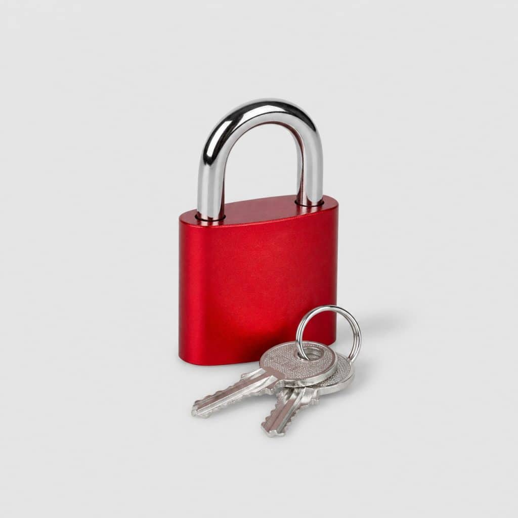 Petit cadenas rouge à clé avec deux clés sur fond clair