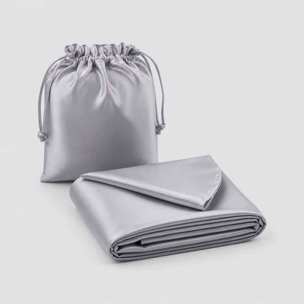 Drap de sac en soie plié avec sa housse sur fond clair